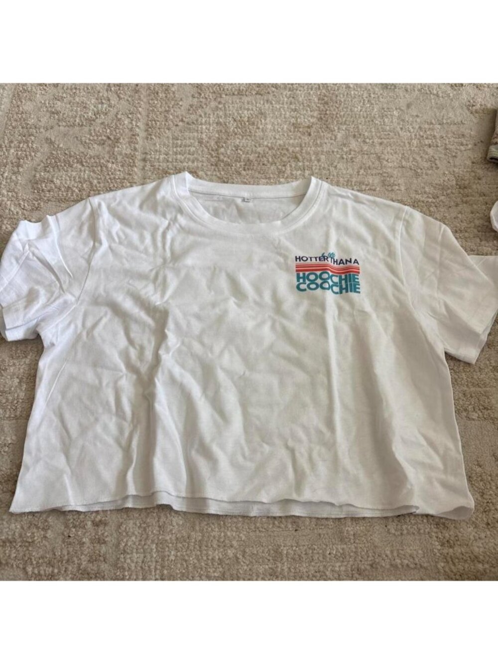 White cropped t-shirt with blue and red text graphic reading